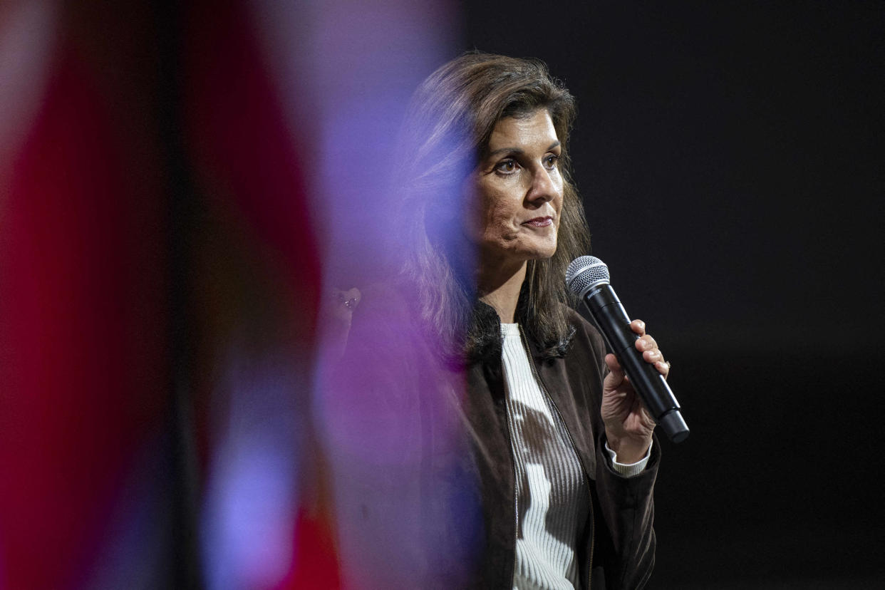 Nikki Haley holds a microphone to her mouth.