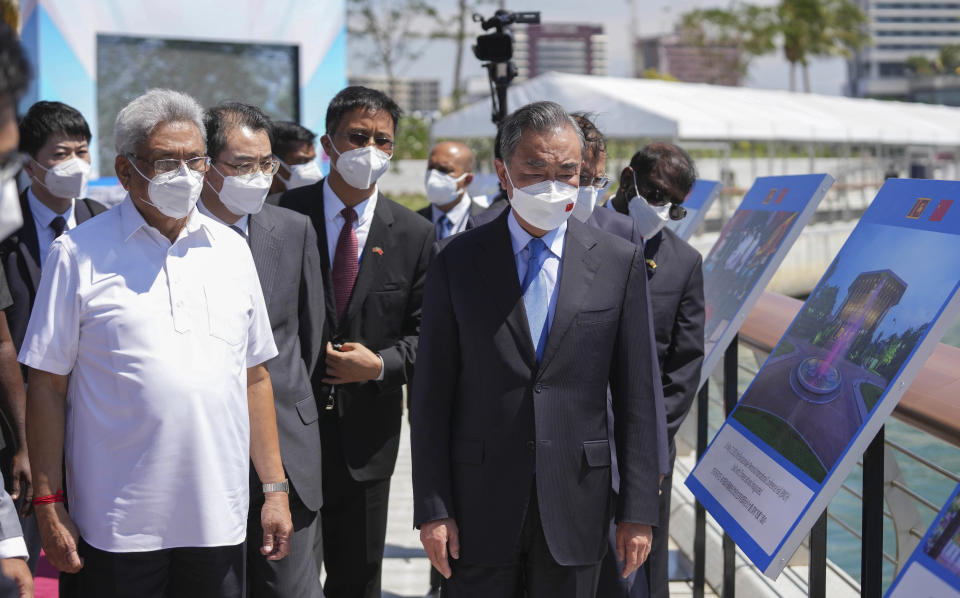 Sri Lankan President Gotabaya Rajapaksa, left, and Chinese Foreign Minister Wang Yi arrive at the Chinese funded sea reclamation Port City project in Colombo, Sri Lanka, Sunday, Jan. 9, 2022. (AP Photo/Eranga Jayawardena)