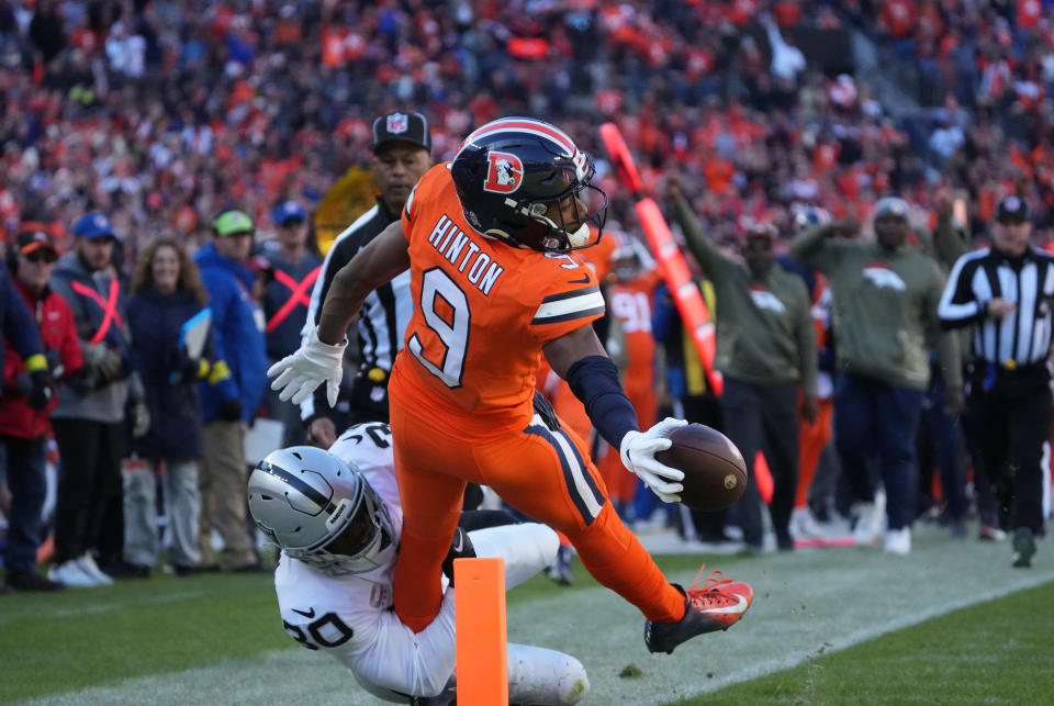 Nov 20, 2022; Denver, Colorado, USA; Denver Broncos wide receiver Kendall Hinton (9) reaches for the end zone as Las Vegas Raiders safety Duron Harmon (30) tackles in the first quarter at Empower Field at Mile High. Mandatory Credit: Ron Chenoy-USA TODAY Sports