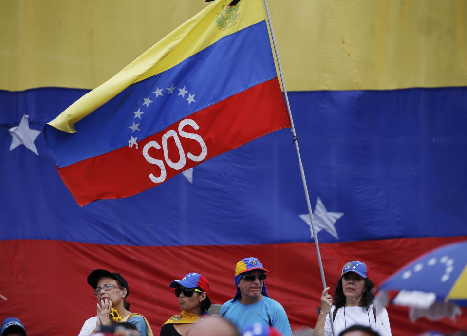 A supporter of Venezuela's opposition leader and self-proclaimed interim president Juan Guaidó, waves a Venezuelan flag marked with the letters "SOS", during a rally in Caracas, Venezuela, Saturday, May 11, 2019. Guaidó has called for nationwide marches protesting the Maduro government, demanding new elections and the release of jailed opposition lawmakers. (AP Photo/Fernando Llano)