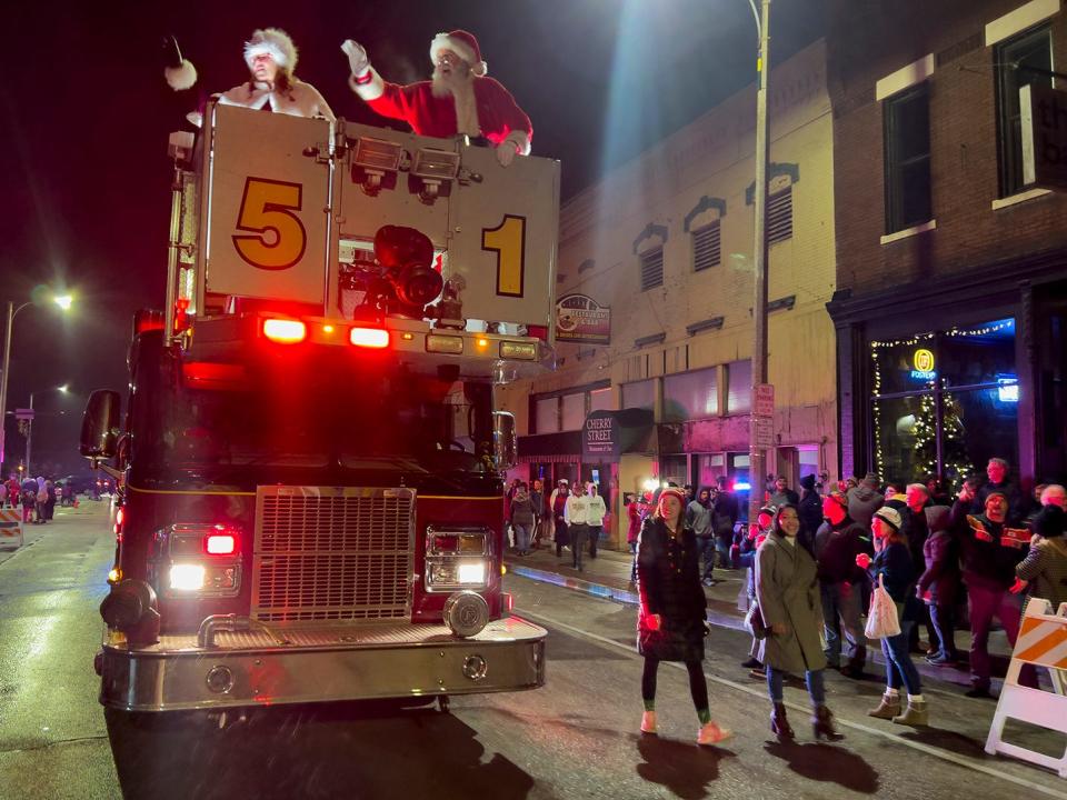 Santa and Mrs. Claus wave from the top of Galesburg Fire Dept. Engine 51 as they make their way down Cherry Street during the Galesburg Downtown Community Partnership Holly Days Parade on Sunday.