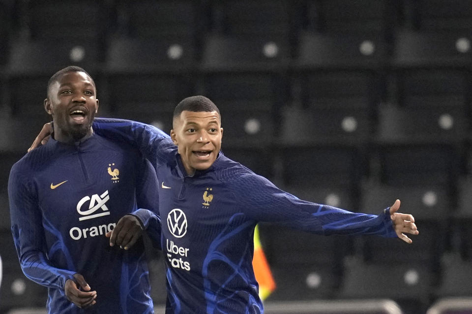 El atacante Kylian Mbappé (derecha) y Marcus Thuram durante un entrenamiento de la selección de Francia, el viernes 16 de diciembre de 2022, en Doha, Qatar. Francia enfrentará a Argentina en la final del Mundial, el 18 de diciembre. (AP Foto/Christophe Ena)