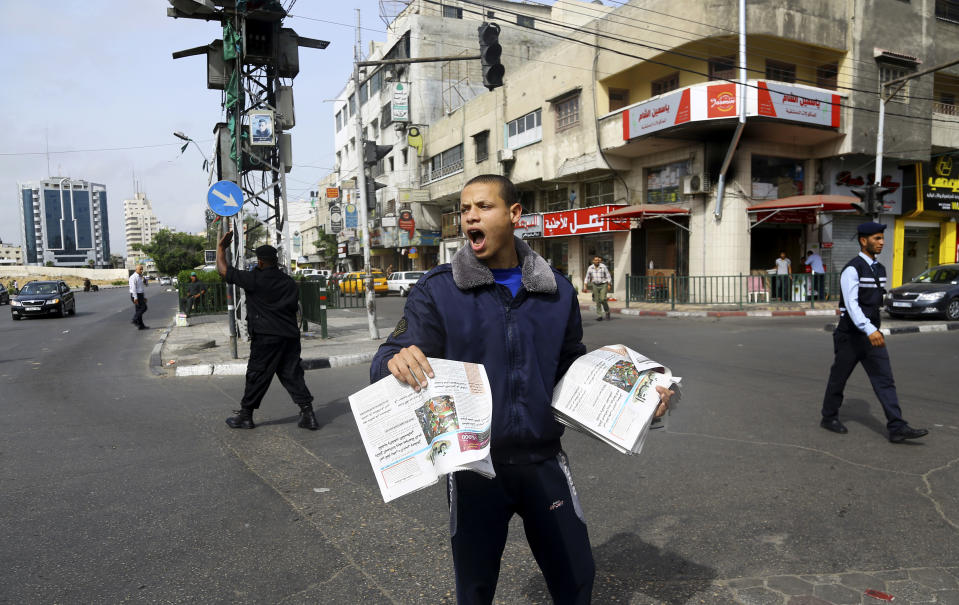 A Palestinian vendor shouts as he sells Al-Quds newspaper on the first day of its arrival to Gaza from the West bank since being banned by Hamas in 2008, in Gaza City, the northern Gaza Strip, Wednesday, May 7, 2014. Gaza’s Hamas rulers on Wednesday permitted a veteran West Bank newspaper to be distributed in the coastal territory for the first time in six years, taking a new step toward implementing a reconciliation deal with the rival West Bank government. (AP Photo/Adel Hana)