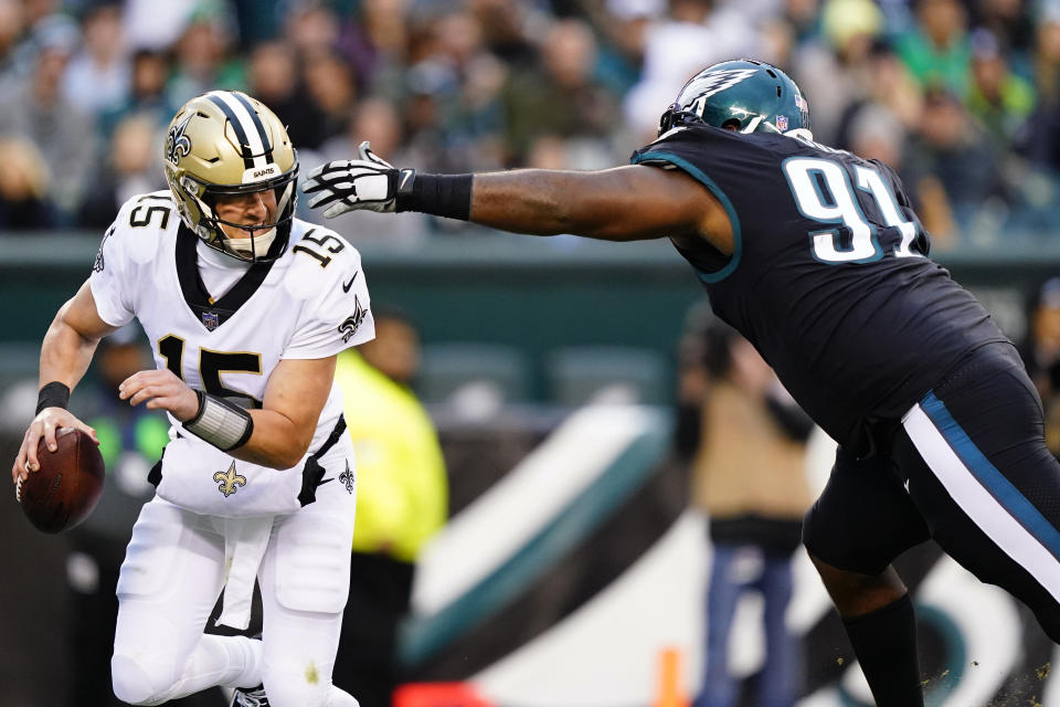 New Orleans Saints' Trevor Siemian (15) slips past Philadelphia Eagles' Fletcher Cox (91) during the second half of an NFL football game, Sunday, Nov. 21, 2021, in Philadelphia. (AP Photo/Matt Rourke)