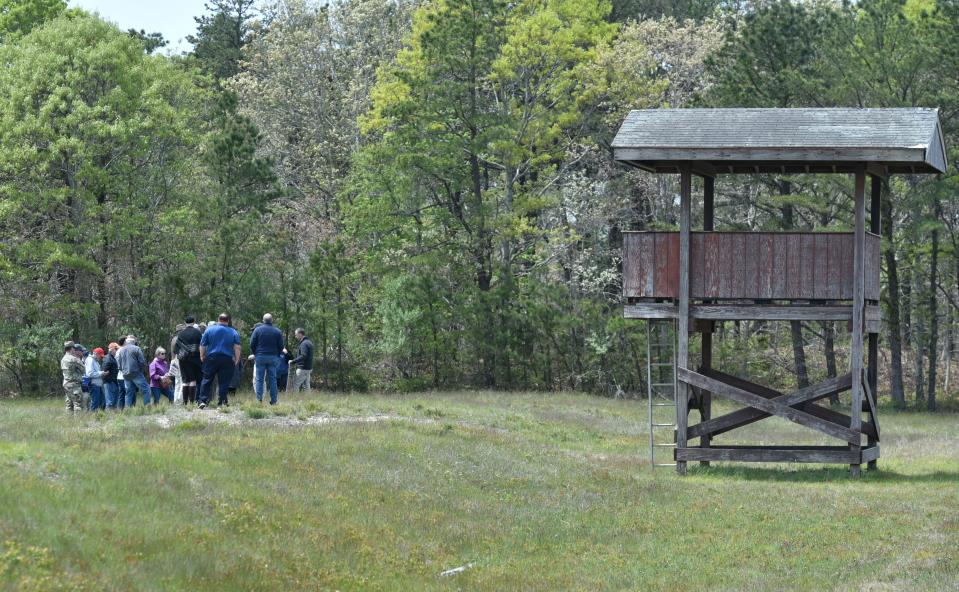 A group visits the Known Distance Range beside its observation tower as part of a tour of Camp Edwards for civilians May 20, 2023. This range is the one proposed to be transformed into a machine gun range. This range is 1000 meters long and was deactivated in 1997.