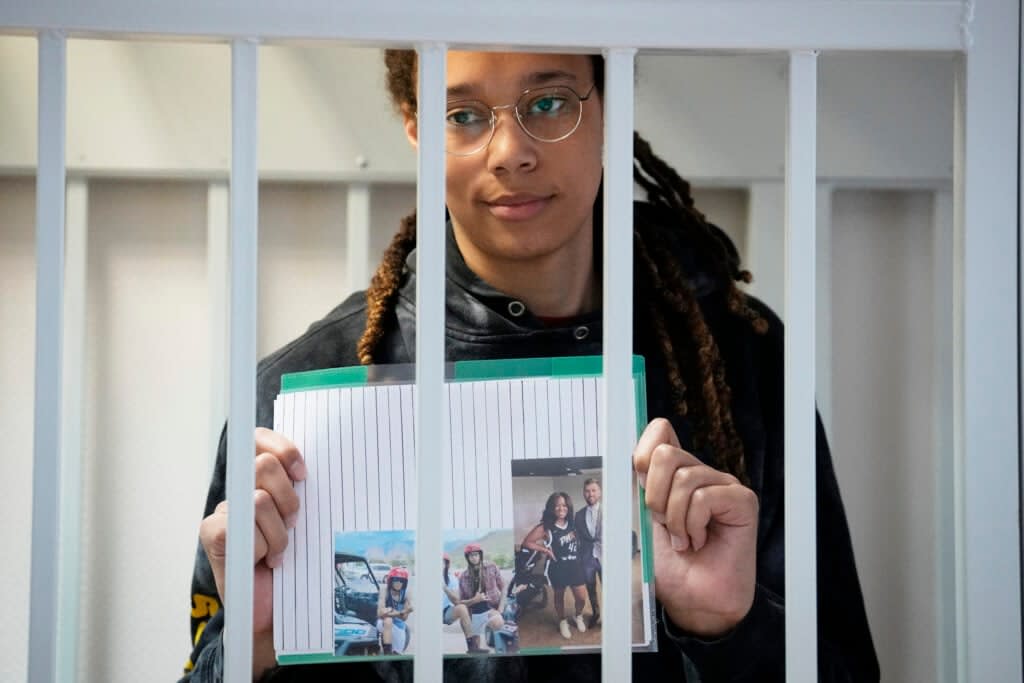 WNBA star and two-time Olympic gold medalist Brittney Griner holds images standing in a cage at a court room prior to a hearing, in Khimki just outside Moscow, Russia, Tuesday, July 26, 2022. (AP Photo/Alexander Zemlianichenko, Pool)