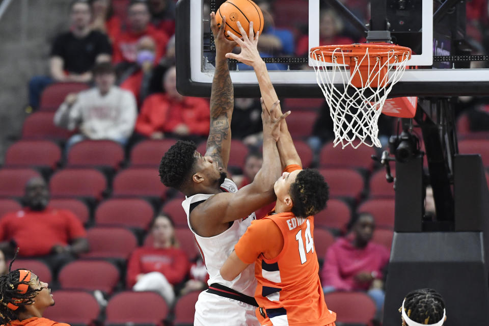 Louisville forward Sydney Curry (21) tries to score over Syracuse center Jesse Edwards (14) during the first half of an NCAA college basketball game in Louisville, Ky., Tuesday, Jan. 3, 2023. (AP Photo/Timothy D. Easley)