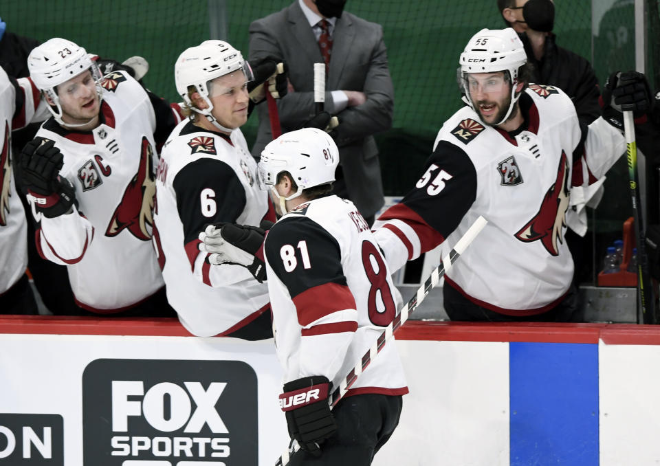 Arizona Coyotes' Oliver Ekman-Larsson (23), of Sweden, Jakob Chychrun (6) and Jason Demers (55) congratulate teammate right wing Phil Kessel (81) on his goal against the Minnesota Wild during the first period of an NHL hockey game Sunday, March 14, 2021, in St. Paul, Minn. (AP Photo/Hannah Foslien)