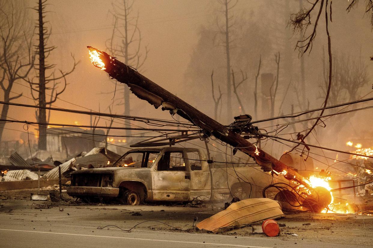 A utility pole burns as the Dixie Fire tears through the Greenville community of Plumas County, Calif. on Wednesday, Aug. 4, 2021. The fire leveled multiple historic buildings and dozens of homes in central Greenville.