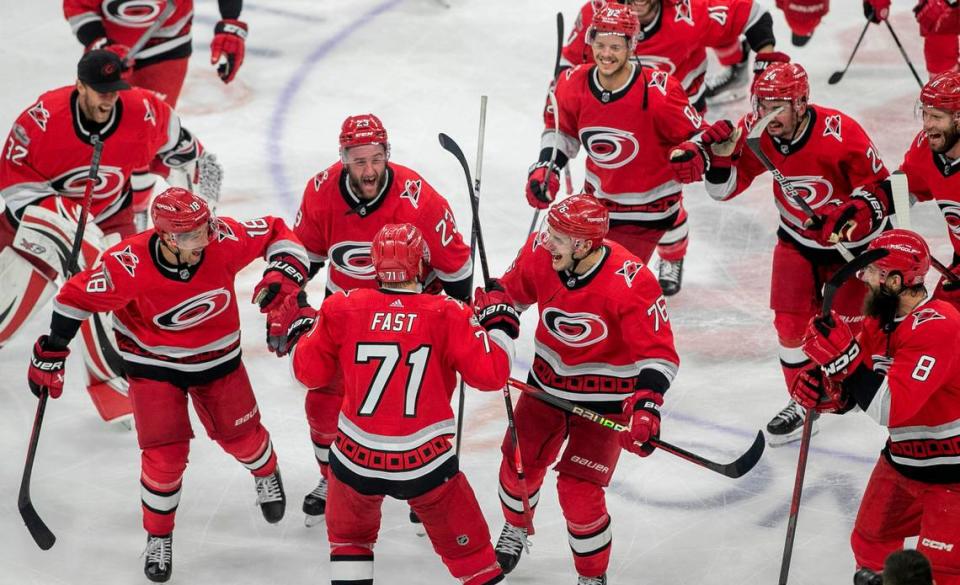 The Carolina Hurricanes swarm to Jesper Fast (71) during their post-game celebration after Fast scored the game winning goal in overtime to secure a 3-2 victory over the New Jersey Devils, clinching their second round Stanley Cup series on Thursday, May 11, 2023 at PNC Arena in Raleigh, N.C.