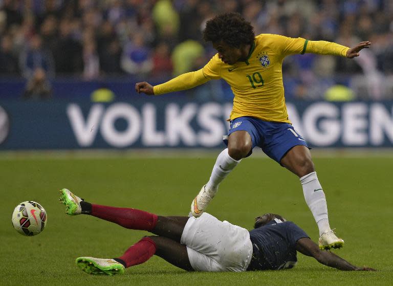 Brazil's forward Willian (up) is tackled by France's defender Mamadou Sakho during their friendly football match on March 26, 2015 at the Stade de France in Saint-Denis, north of Paris