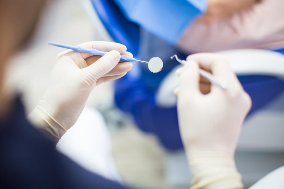 POV shot of male dentist with dental tools in hand. Dentist at work with surgical gloves and tools in hand.