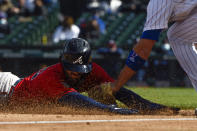 Atlanta Braves Dansby Swanson is tagged at third base by Chicago Cubs third baseman Kris Bryant during the fifth inning of a baseball game against the Friday, April 16, 2021, in Chicago. (AP Photo/Matt Marton)