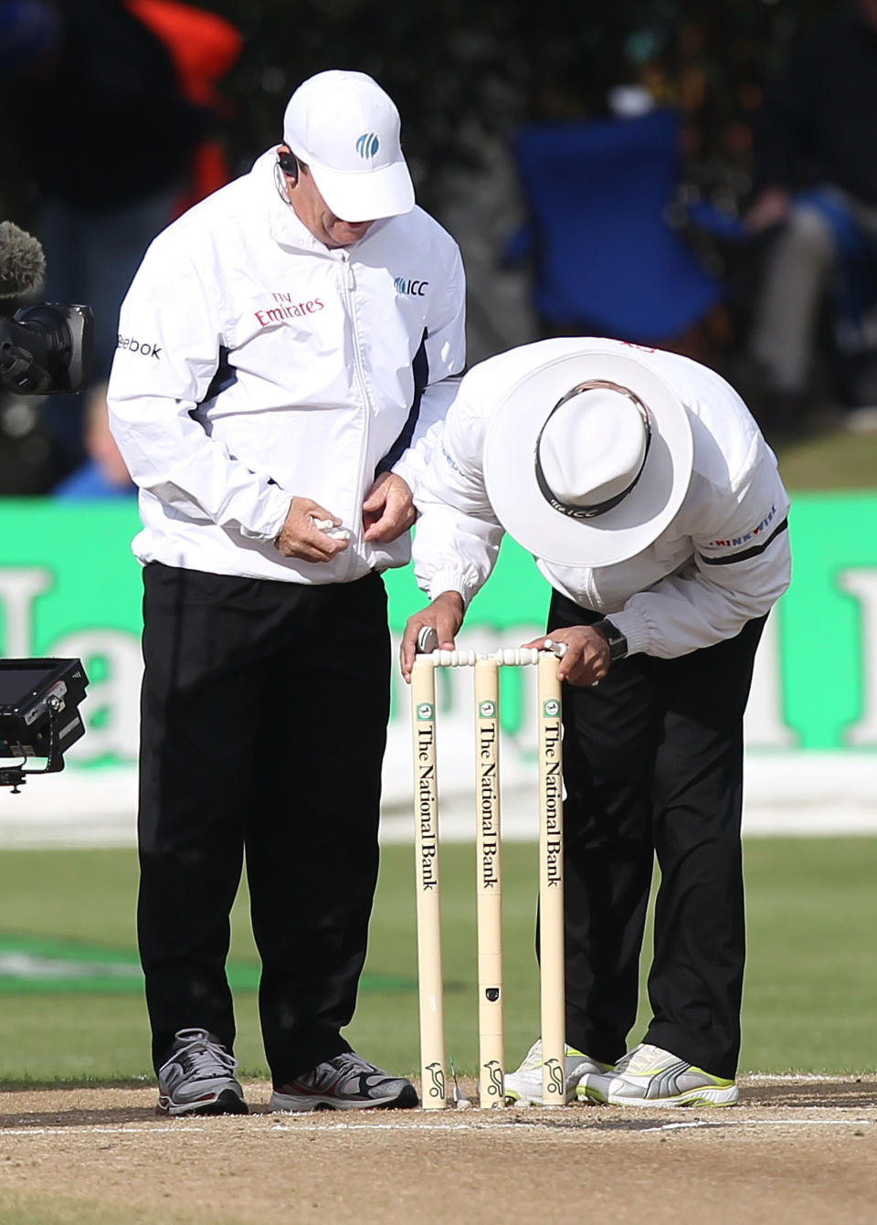 Umpire Aleem Dar (right) fits heavier bails on top of the stumps with reserve umpire Gav Baxter after the wind blew them off during Day 4 of the first Test match between New Zealand and South Africa at the University Oval in Dunedin on March 10, 2012.