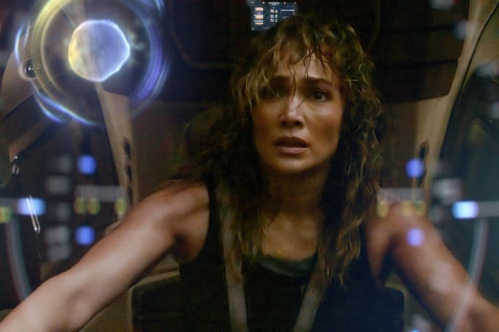 Jennifer Lopez sits in an AI robot suit and stares at the screen.