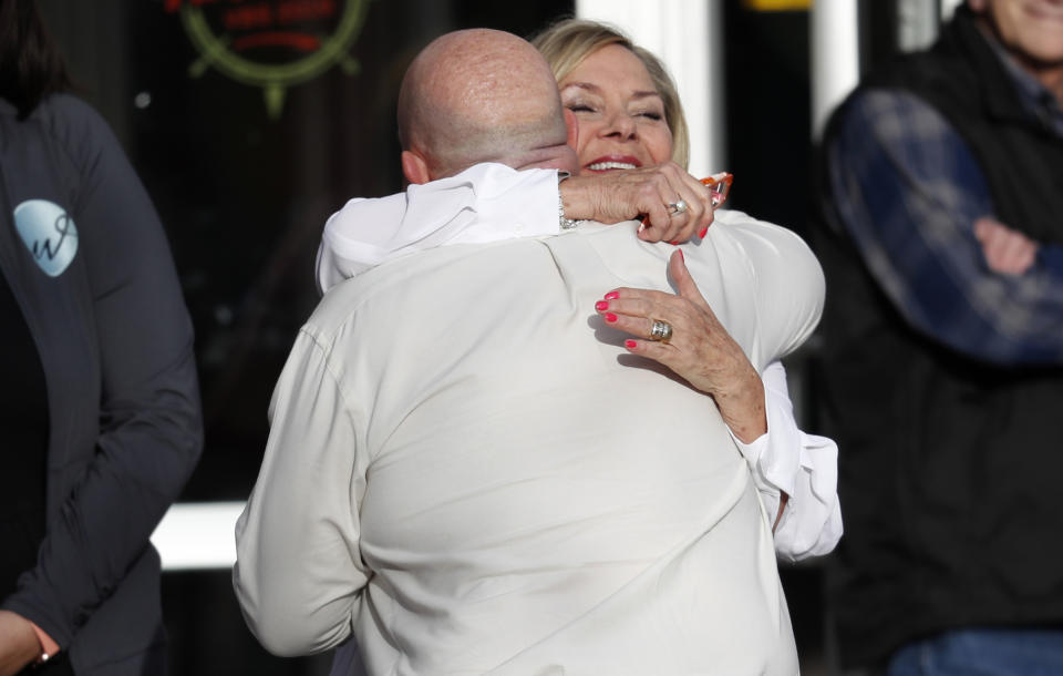 CORRECTS LAST NAME TO WOYDZIAK Beth Woydziak, back, hugs a participant as he arrives to attend a faith-based memorial service for the victims of the massacre at Columbine High School nearly 20 years ago at a community church Thursday, April 18, 2019, in Littleton, Colo. (AP Photo/David Zalubowski)