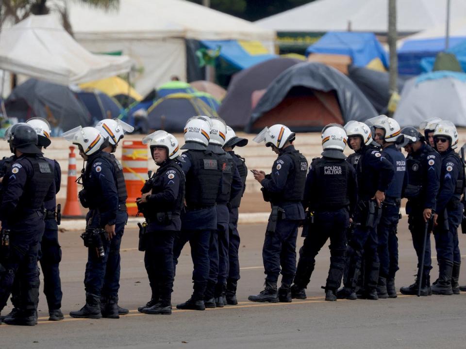 Security forces stand guard as supporters of Brazil's former President Jair Bolsonaro leave a camp outside the the army headquarters in Brasilia (Reuters)