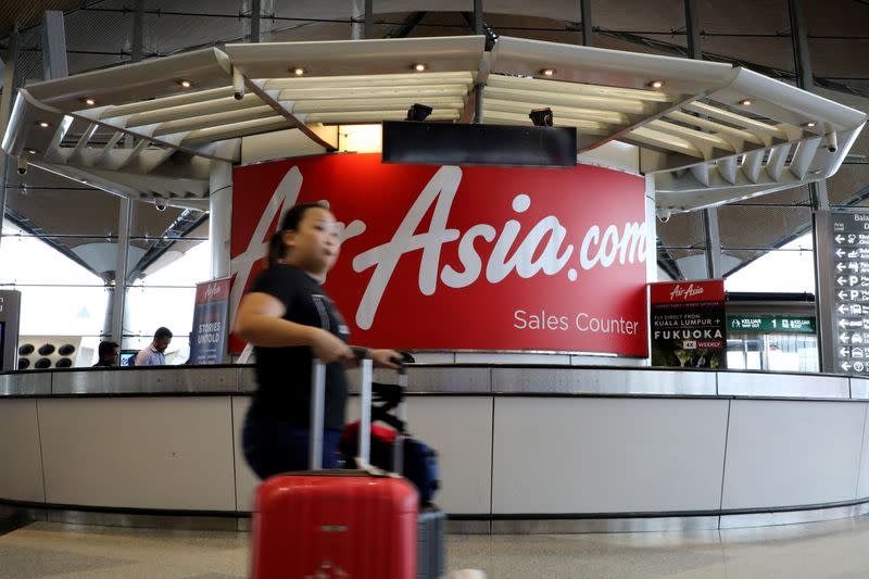 A woman walks past an AirAsia counter at Kuala Lumpur International Airport in Sepang