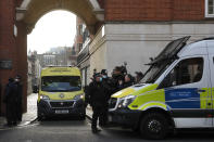 Police officers stand at an entrance to the King Edward VII Hospital where Prince Philip is being treated for an infection, as an ambulance is driven out, in London, Monday, March 1, 2021. (AP Photo/Frank Augstein)