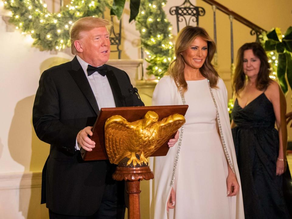 President Donald Trump, flanked by first lady Melania Trump, speaks in the Grand Foyer of the White House during the Congressional Ball on 12 December 2019: Manuel Balce Ceneta/AP