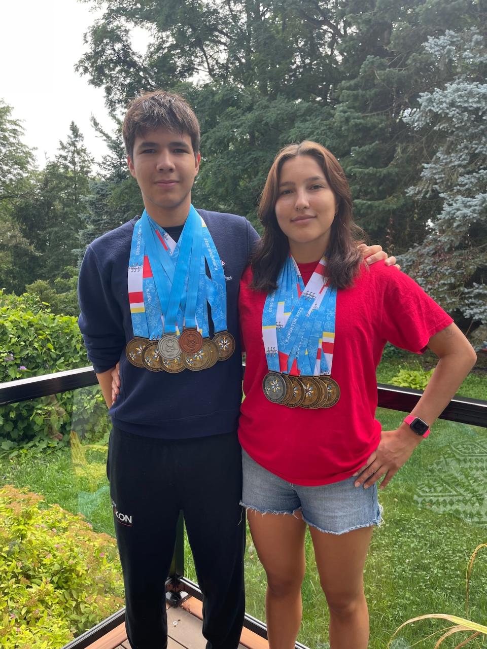 Siblings Tuja Dreyer, left, and Kassua Dreyer from Ross River, Yukon, pose with the swimming medals they each won at the 2023 North American Indigenous Games in Halifax.