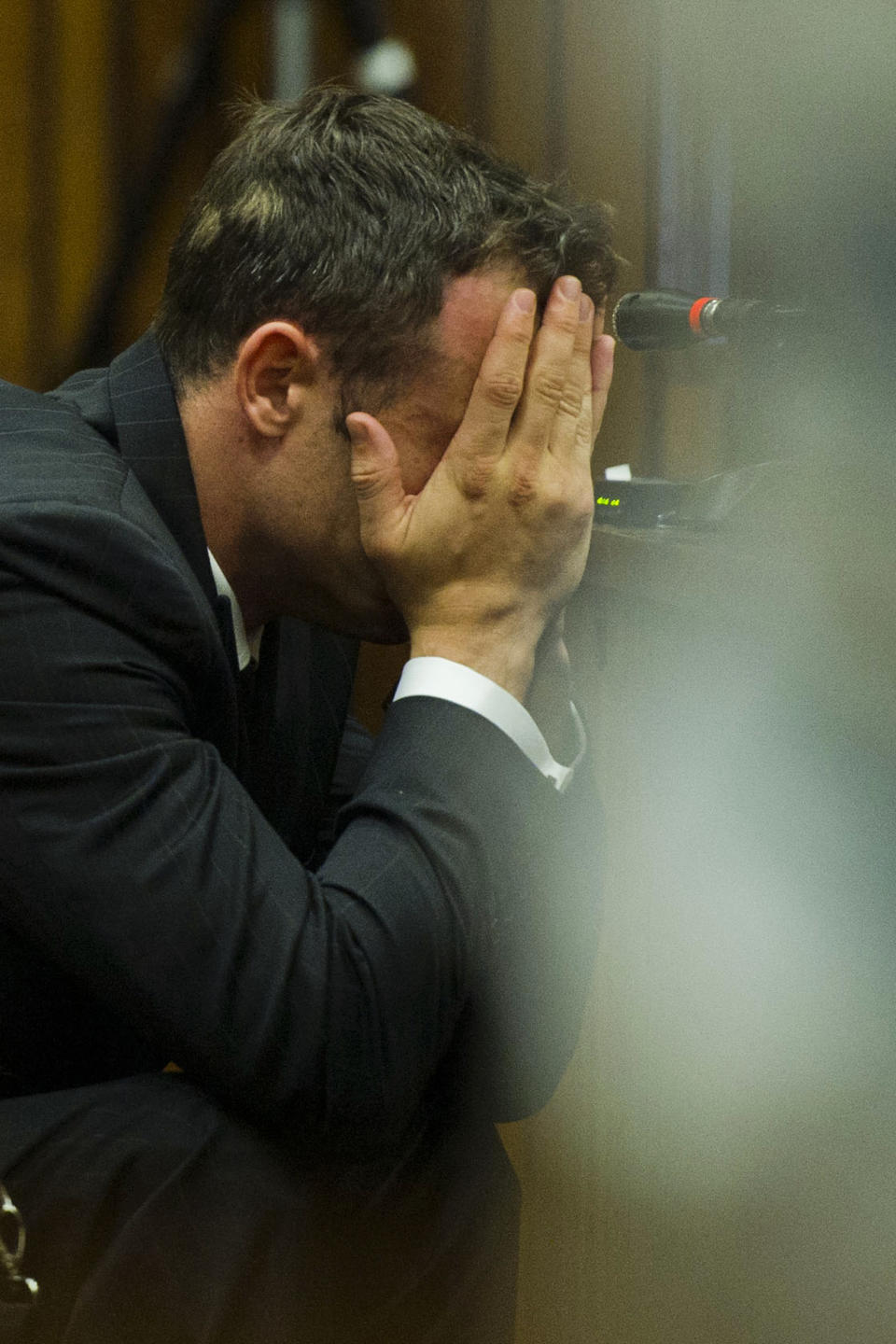 Oscar Pistorius covers his face with his hands as he listens to forensic evidence during his trial in court in Pretoria, South Africa, Thursday, March 13, 2014. Pistorius is charged with the shooting death of his girlfriend Reeva Steenkamp, on Valentines Day in 2013. (AP Photo/Alet Pretorius, Pool)