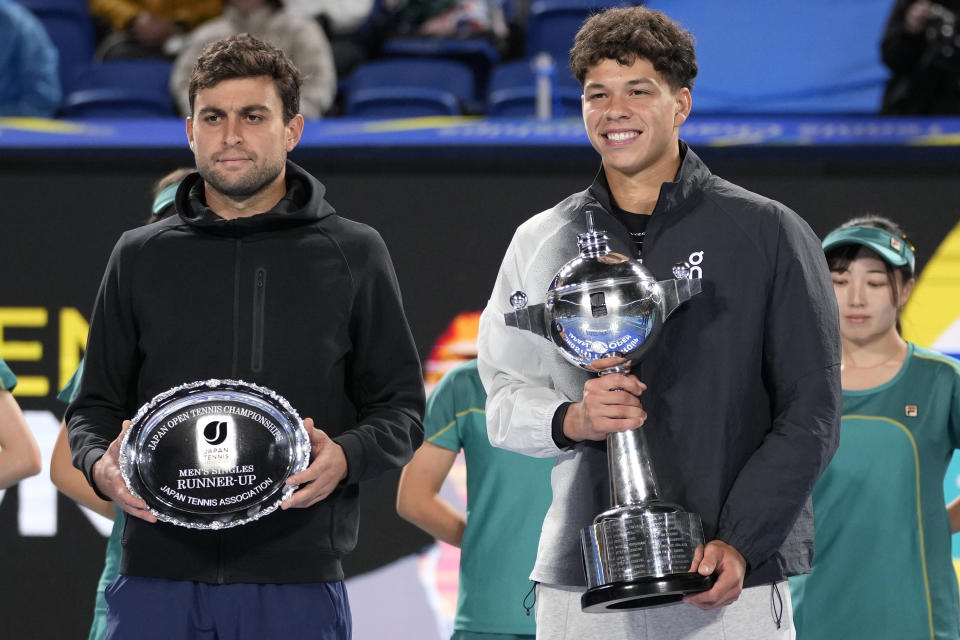 Ben Shelton, right, of the U.S. holds the winning trophy with runner-up Aslan Karatsev, left, of Russia during the awarding ceremony of the men's singles final of Japan Open tennis championships in Tokyo, Japan, Sunday, Oct. 22, 2023.(AP Photo/Shuji Kajiyama)