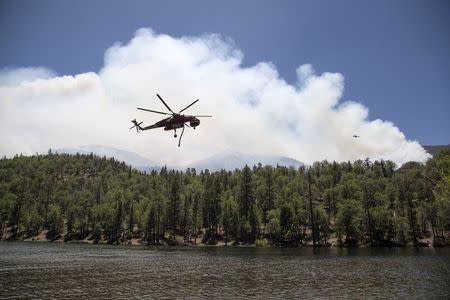 Firefighting helicopters fill up with water from Jenks Lake as firefighters battle the Lake Fire in the San Bernardino National Forest, California June 19, 2015. REUTERS/David McNew