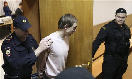 Bolshoi Theatre dancer Pavel Dmitrichenko (C), who is on trial for ordering an acid attack on the artistic director of Russia's Bolshoi ballet Sergei Filin, is escorted out of a court room in Moscow, November 6, 2013. REUTERS/Sergei Karpukhin