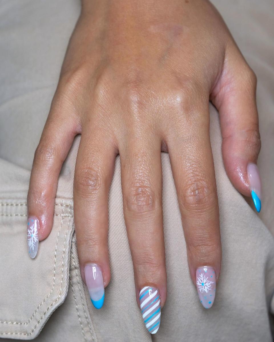 a persons hand with painted nails in a blue and pink holiday theme