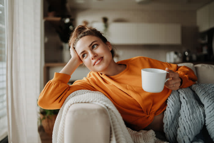 mujer tomando un café en el sofá