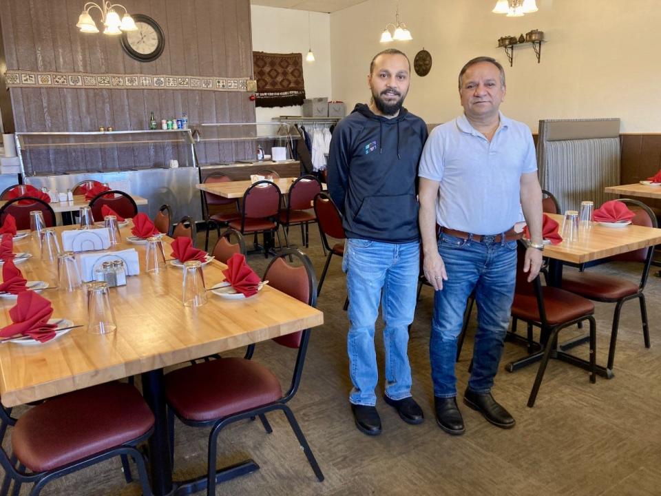 Bhimlal Basel (right) and his son Yuvraj (left) stand in the dining room of their restaurant Aamchi Mumbai at 1129 US-31 in Petoskey.