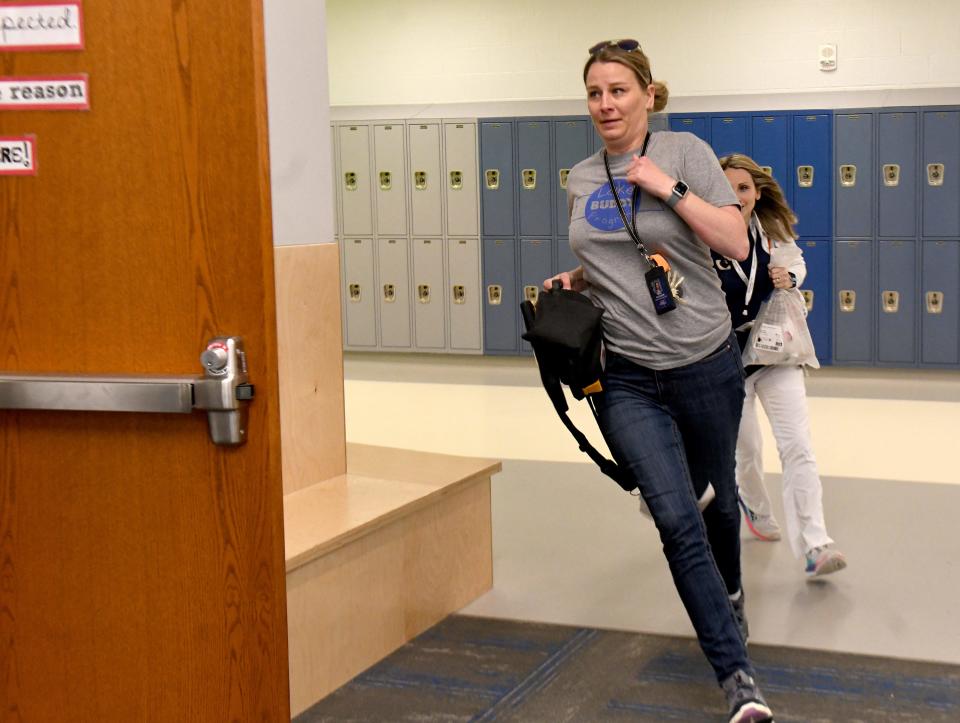 Lake Middle/High School intervention specialist Katrina Gaughan rushes to a classroom Thursday during a sudden cardiac arrest drill. Lake Local Schools is seeking to become the first Stark County school district to have all of its schools designated as heart safe schools through Project ADAM.