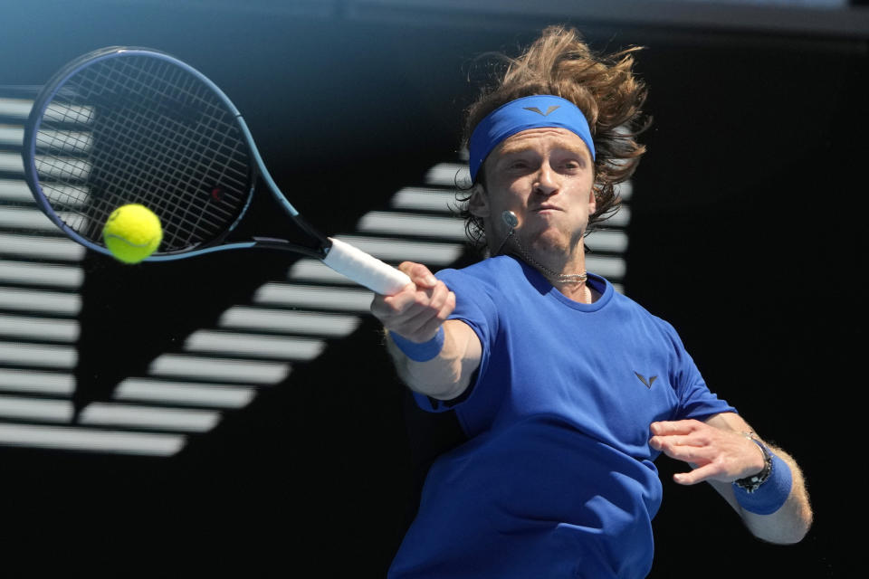 El ruso Andrey Rublev devuelve de derecha al británico Daniel Evans durante su partido de tercera ronda del Abierto de Australia, en Melbourne, Australia, el sábado 21 de enero de 2023. (AP Foto/Ng Han Guan)