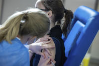 A healthcare worker administers a dose of the AstraZeneca COVID-19 vaccine to a woman at the Brussels Expo center in Brussels, Thursday, March 4, 2021. The Expo is one of the largest vaccination centers in Belgium. (AP Photo/Olivier Matthys)