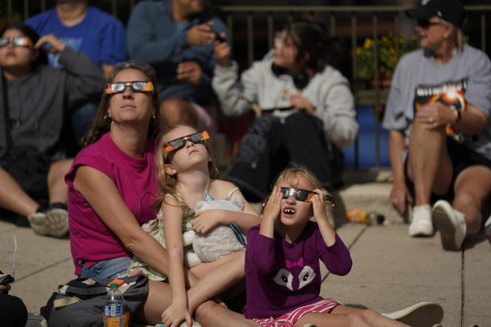 Viewers watch the moon moves begins to move in front of the sun during an annular solar eclipse for ring of fire, Saturday, Oct. 14, 2023, from San Antonio. (AP Photo/Eric Gay)