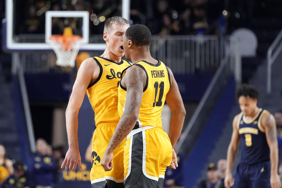 Iowa forward Payton Sandfort (20) and guard Tony Perkins (11) react after a play during the second half of an NCAA college basketball game against Michigan , Saturday, Jan. 27, 2024, in Ann Arbor, Mich. (AP Photo/Carlos Osorio)