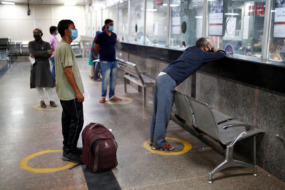 People stand in a queue within marks of social distancing at a Railway reservation ticket counter after a few restrictions were lifted during an extended nationwide lockdown to slow the spread of the coronavirus disease (COVID-19), in New Delhi, India, June 1, 2020. REUTERS/Adnan Abidi