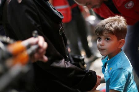 A boy, a relative of a rebel fighter, waits to board a bus to evacuate the besieged Waer district in the central Syrian city of Homs, after a local agreement reached between rebels and Syria's army, Syria September 22, 2016. REUTERS/Omar Sanadiki