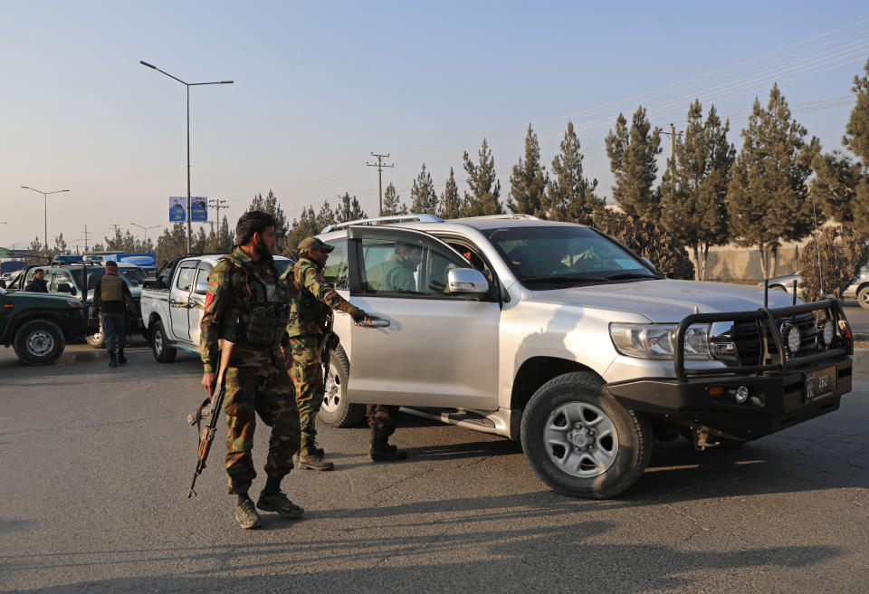 Afghan police search a car at a temporary checkpoint in Kabul, Afghanistan, Monday, Jan.18, 2021. Residents of the Afghan capital Kabul rarely go out after dark and increasingly are sending their children to safety outside the city in the face of deteriorating security. Bombings have been frequent the past months, not just large-scale attacks but also targeted bombings that often kill or wound bystanders. (AP Photo/Mariam Zuhaib)