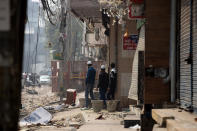 A group of Muslims stand on a street that saw violence on Tuesday in New Delhi, India, Wednesday, Feb. 26, 2020. At least 20 people were killed in three days of clashes in New Delhi, with the death toll expected to rise as hospitals were overflowed with dozens of injured people, authorities said Wednesday. The clashes between Hindu mobs and Muslims protesting a contentious new citizenship law that fast-tracks naturalization for foreign-born religious minorities of all major faiths in South Asia except Islam escalated Tuesday. (AP Photo/Rajesh Kumar Singh)