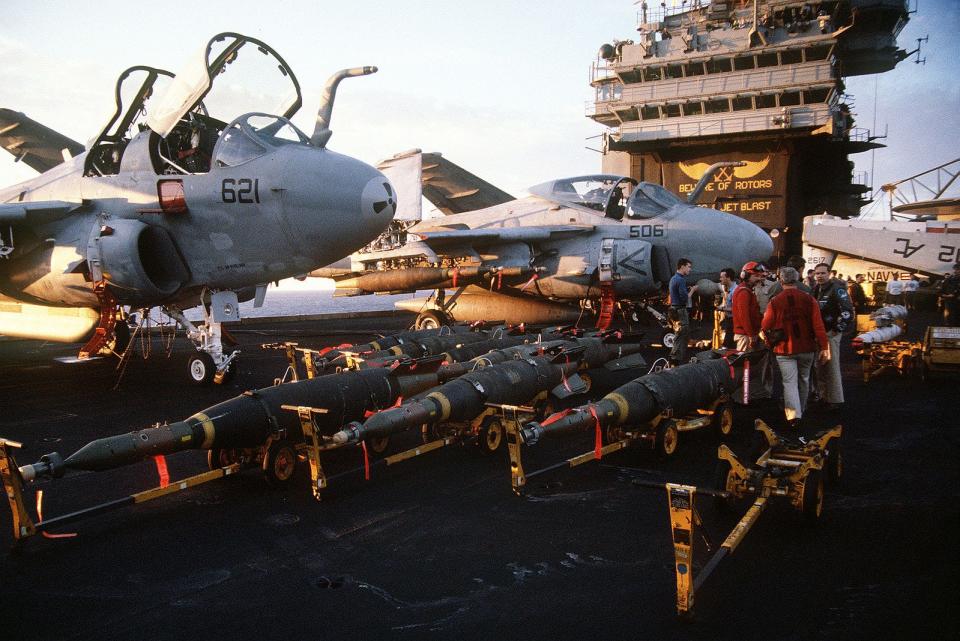 Laser-guided bombs line the flight deck of the aircraft carrier USS John F. Kennedy