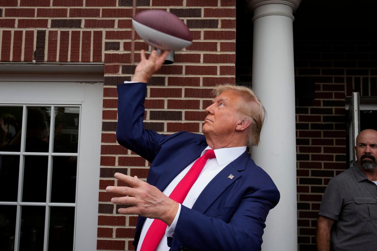 Former President Donald Trump throws a football to the crowd during a visit to the Alpha Gamma Rho, agricultural fraternity, at Iowa State University before an NCAA college football game between Iowa State and Iowa on Sept. 9 in Ames, Iowa.