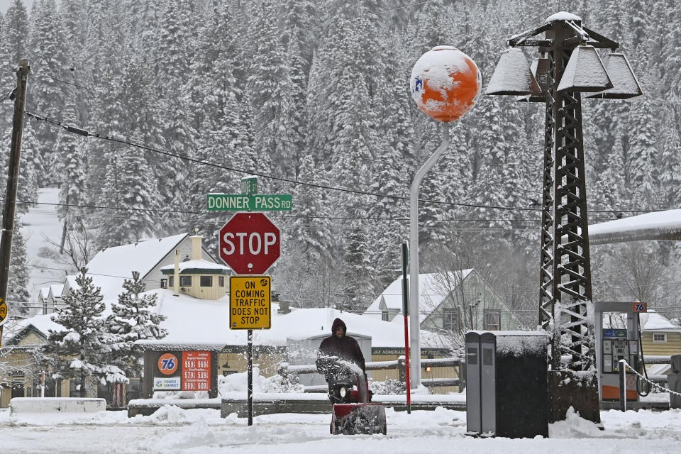 Juan Manuel plows the snow off the sidewalk in front of The Bar of American where he is employed on Friday, March 1, 2024, in downtown Truckee, Calif. The most powerful Pacific storm of the season is forecast to bring up to 10 feet of snow into the Sierra Nevada by the weekend (AP Photo/Andy Barron)