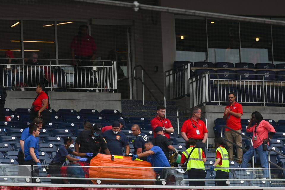 Medical personal use a stretcher to assist a spectator in the seventh inning of the game between the Washington Nationals and the Milwaukee Brewers at Nationals Park on June 11.