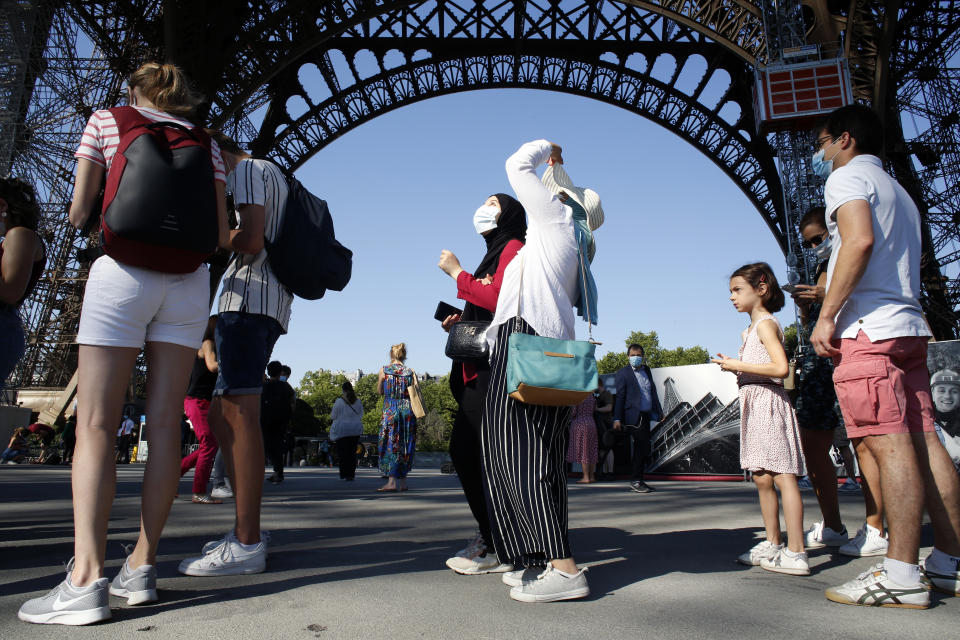 People queue up prior to visit the Eiffel Tower, in Paris, Thursday, June 25, 2020. The Eiffel Tower reopens after the coronavirus pandemic led to the iconic Paris landmark's longest closure since World War II. (AP Photo/Thibault Camus)