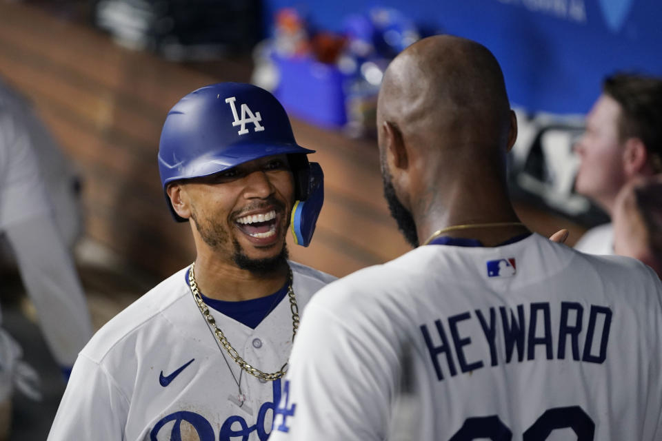 Los Angeles Dodgers' Mookie Betts celebrates with Jason Heyward in the dugout after Betts hit a home run against the Arizona Diamondbacks during the sixth inning of a baseball game Tuesday, Aug. 29, 2023, in Los Angeles. (AP Photo/Ryan Sun)