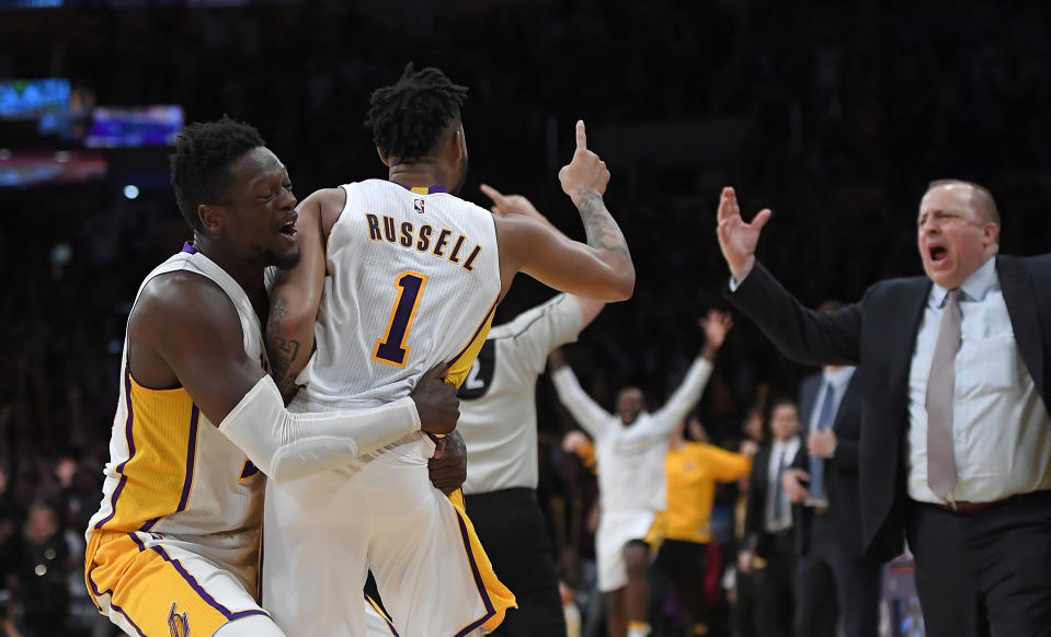 Los Angeles Lakers guard D'Angelo Russell, center, is hugged by forward Julius Randle, left, after hitting a game-winning three point shot as Minnesota Timberwolves head coach Tom Thibodeau reacts during the second half of an NBA basketball game, Sunday, April 9, 2017, in Los Angeles. The Lakers won 110-109. (AP Photo/Mark J. Terrill)