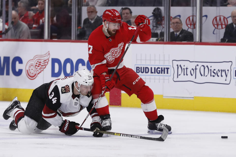 Arizona Coyotes center Carl Soderberg (34) and Detroit Red Wings defenseman Filip Hronek (17) battle for the puck during the second period of an NHL hockey game, Sunday, Dec. 22, 2019, in Detroit. (AP Photo/Carlos Osorio)