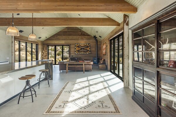 The interior spaces exude a warm, rustic aesthetic, in large part to the wooden beams, wood-paneled walls and ceilings, as well as the polished concrete lining the floors.